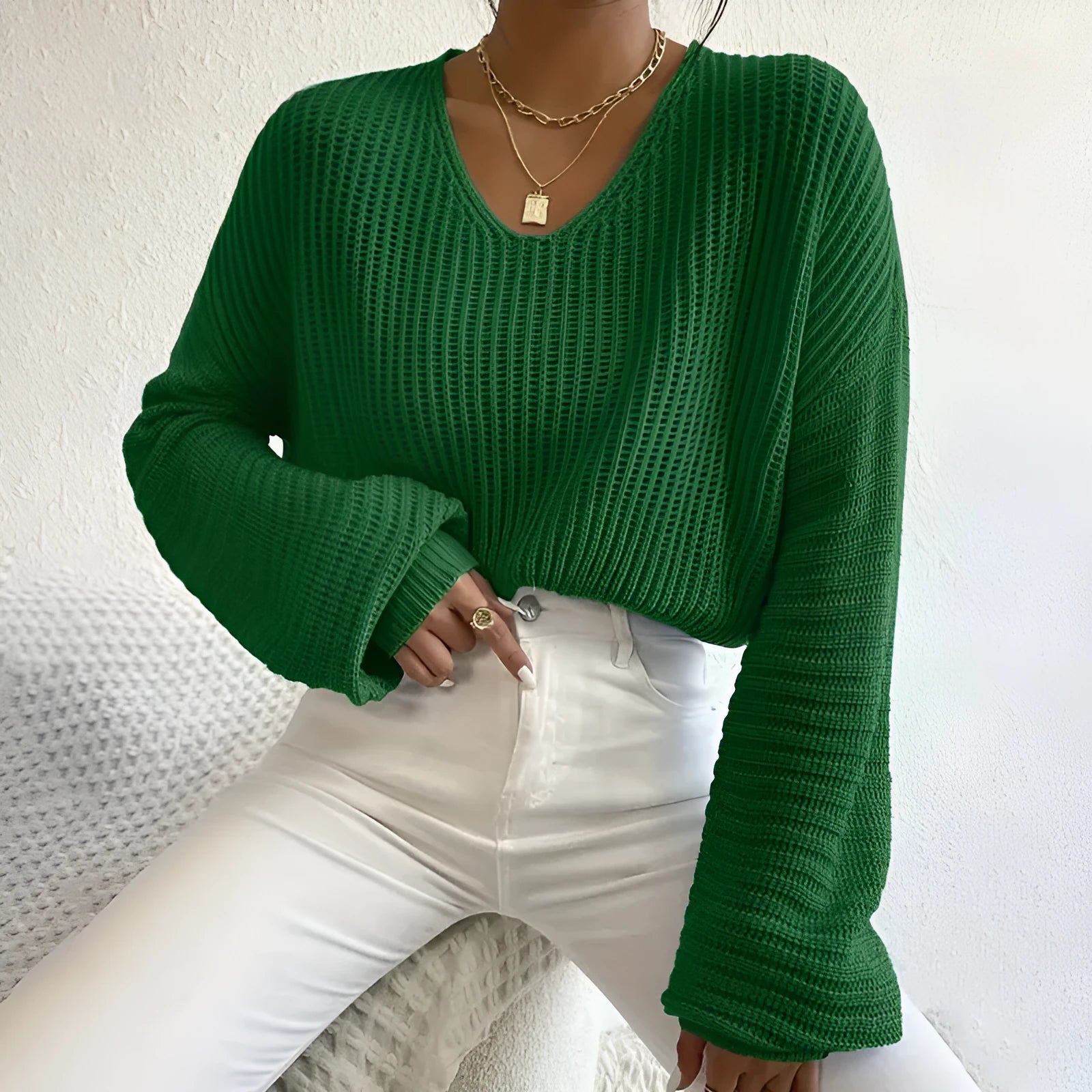 A woman wearing a solid colour long sleeve loose pullover top in a casual setting.