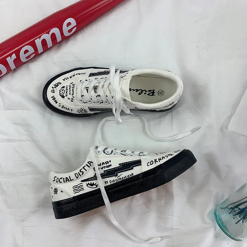 Women's white canvas shoes low top with lace-up tie and graffiti pattern on non-slip vulcanised sole