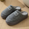 Men's brown suede slippers with a thickened design and textured EVA sole, shown on a wooden floor.
