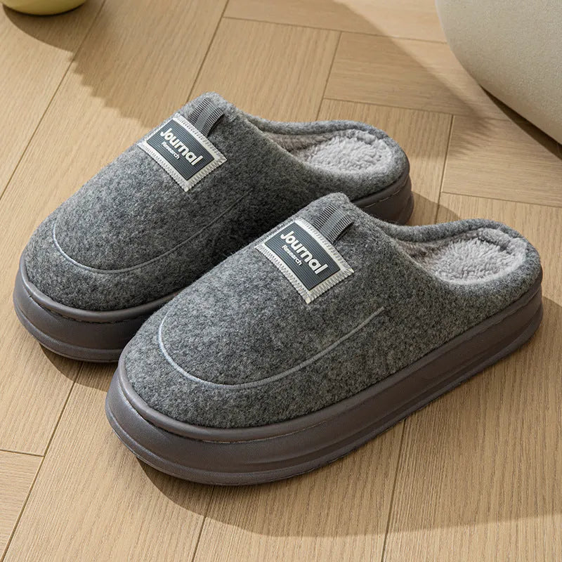 Men's brown suede slippers with a thickened design and textured EVA sole, shown on a wooden floor.