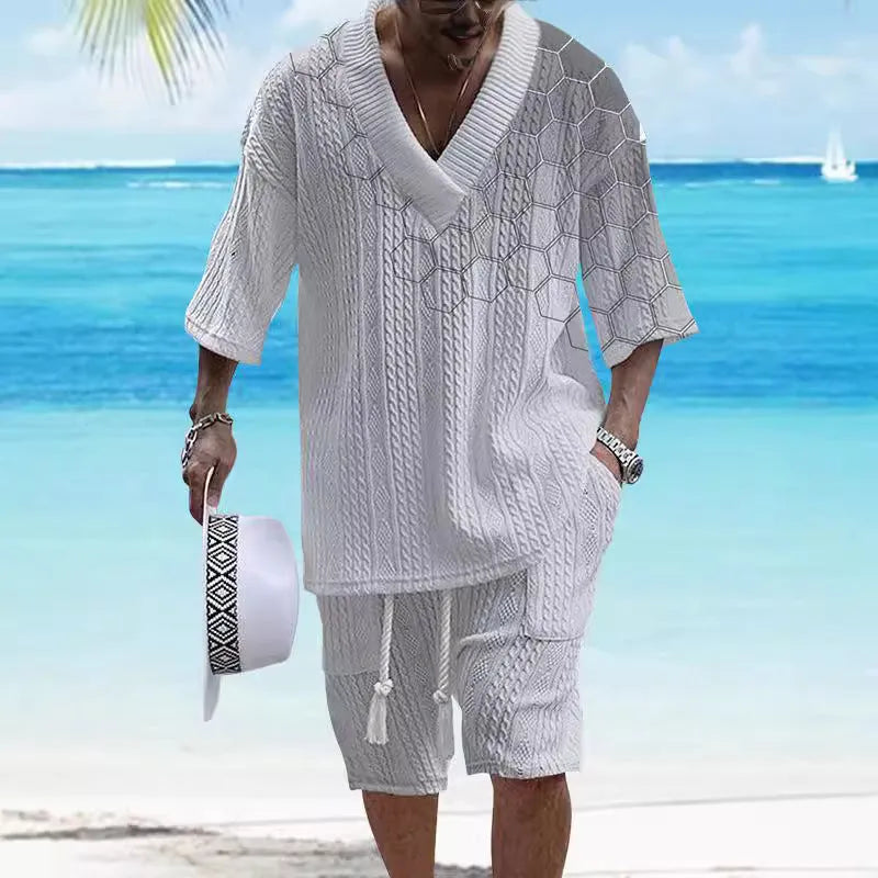 Man wearing a solid colour knitted short-sleeved top and matching shorts, showing the drop-shoulder design.