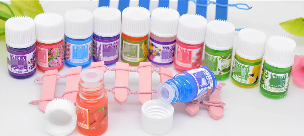 Box of 12 round plastic aromatherapy oil bottles, 25-50mL, featuring lemon, rose, jasmine, lavender floral scents