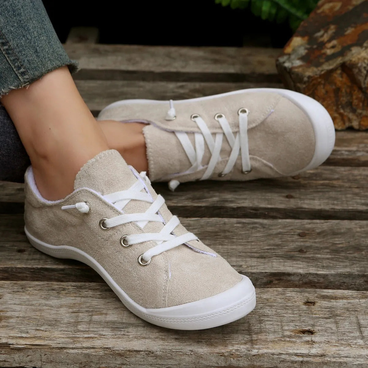 Women's creamy white low-top fabric sneakers with a casual rubber sole on a neutral background