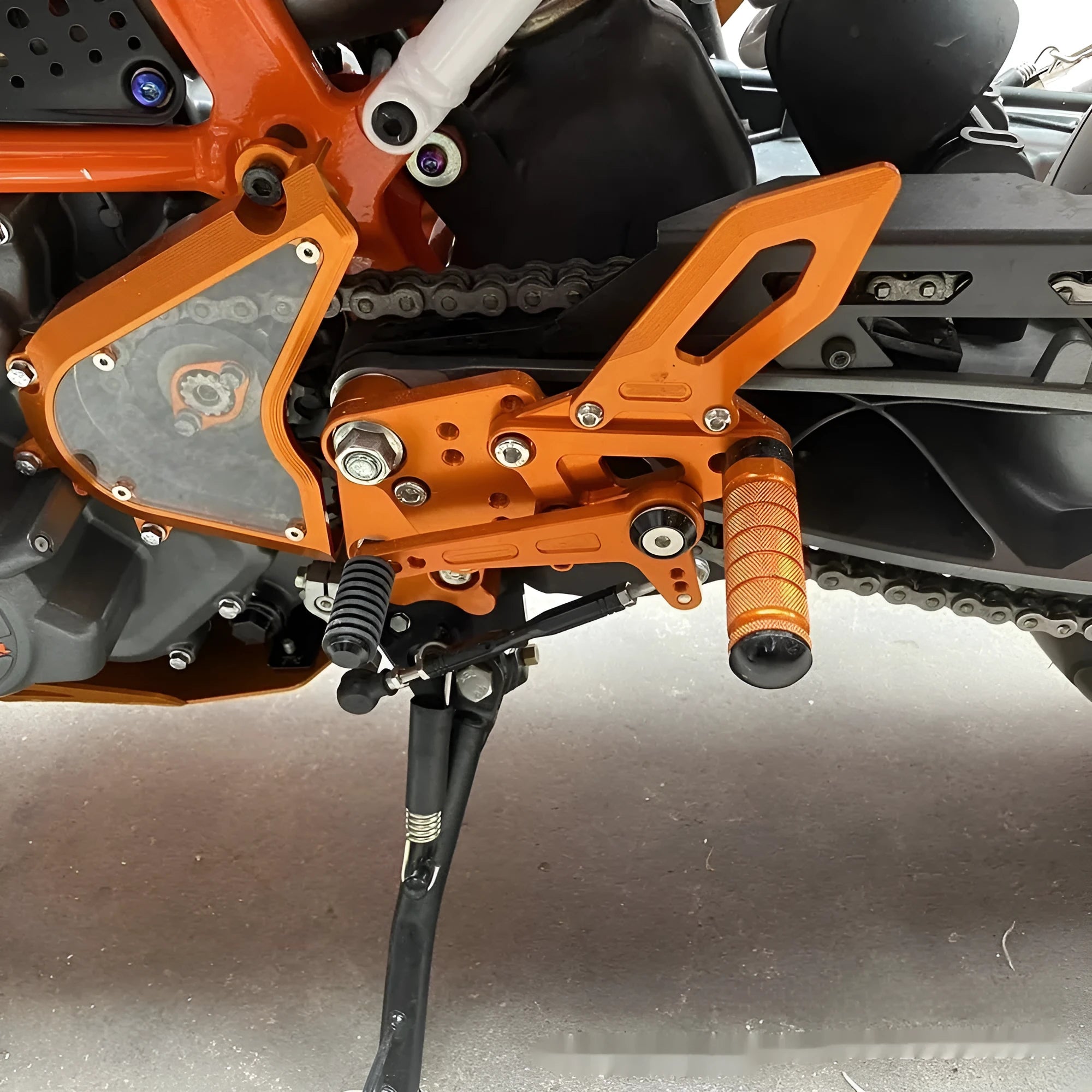 KTM DUKE motorcycle raised footrest relocation kit in black and orange colours