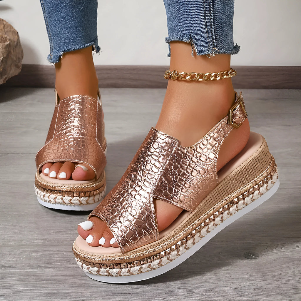 Gold Roman sandals with hollow-out pattern and ankle buckle on model foot