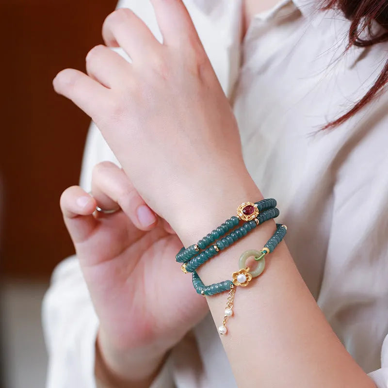 Blue water jade abacus bead bracelet with tourmaline and pearl accents on a wrist