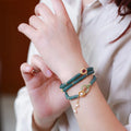 Blue water jade abacus bead bracelet with tourmaline and pearl accents on a wrist