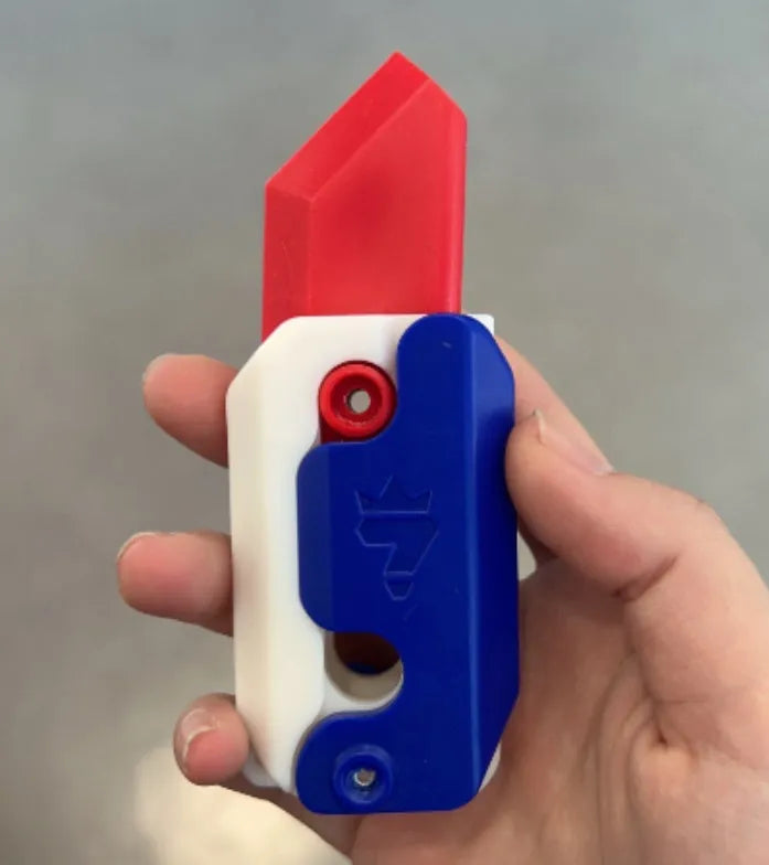 3D printed carrot gravity fidget knife in orange purple green colour, showing blade partly extended from sheath
