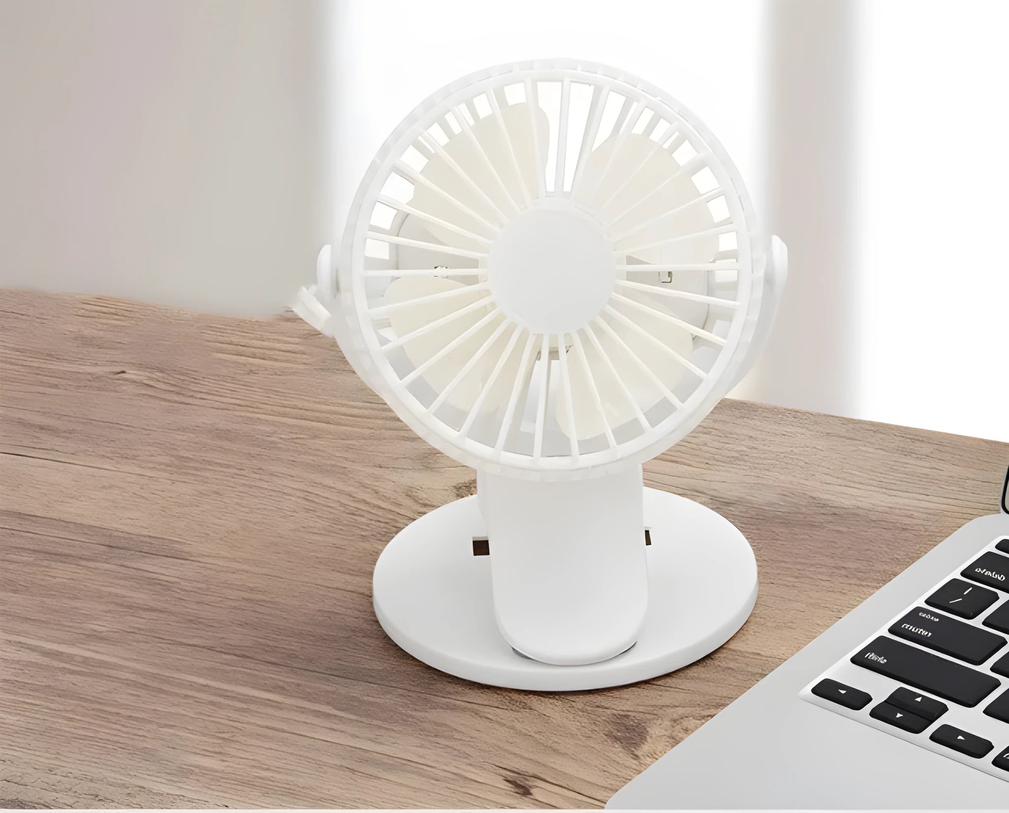 White USB rechargeable clip fan with plastic blades attached to a stroller.