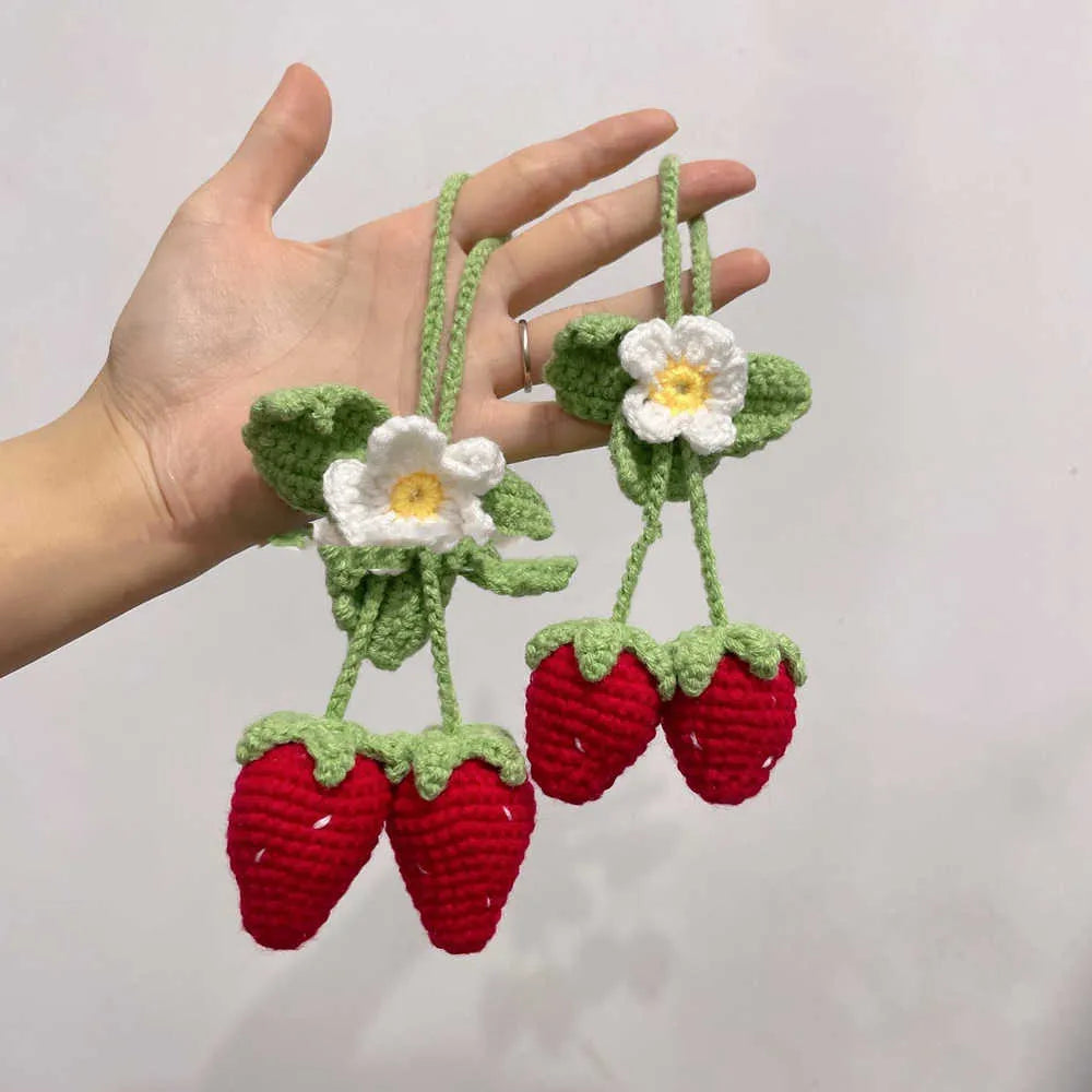 Handmade woven strawberry-shaped car pendant decoration in natural cotton and hemp fibres.