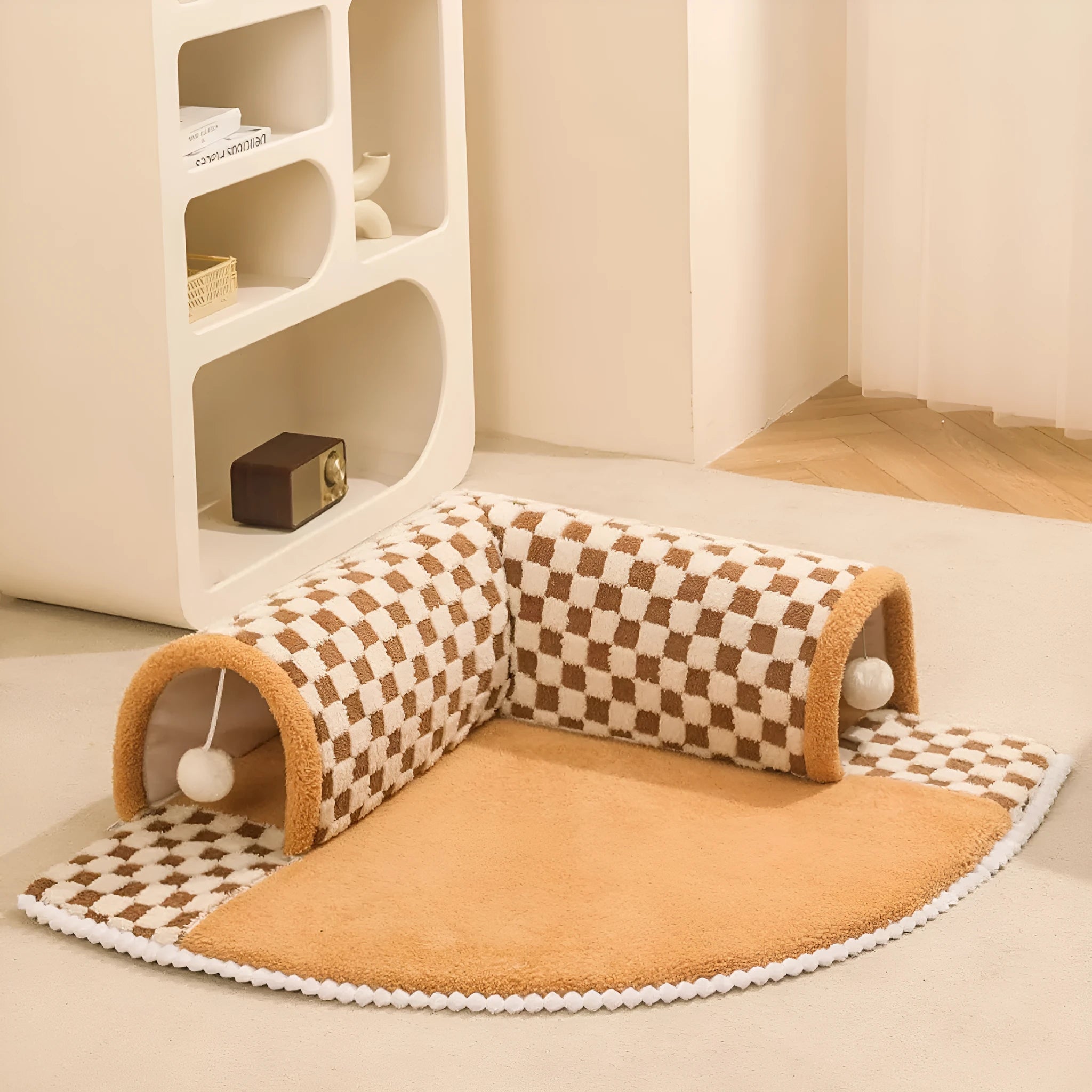 Large plush fan-shaped dog and cat bed with central tunnel, in coffee colour, on a floor.