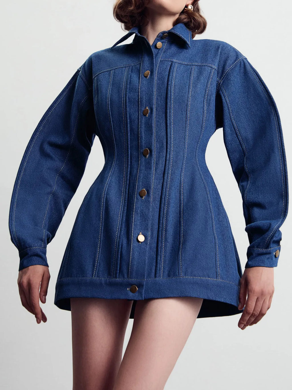 Blue denim corset-style shirt dress with patchwork design and statement buttons on a model, mini length