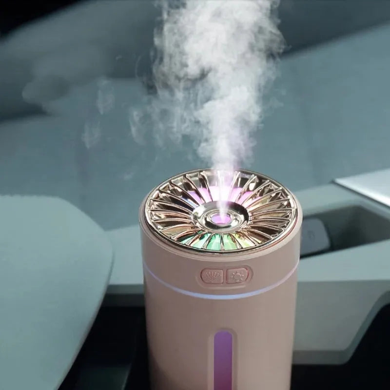 Compact black wireless USB humidifier with colourful LED lights on a car cup holder.