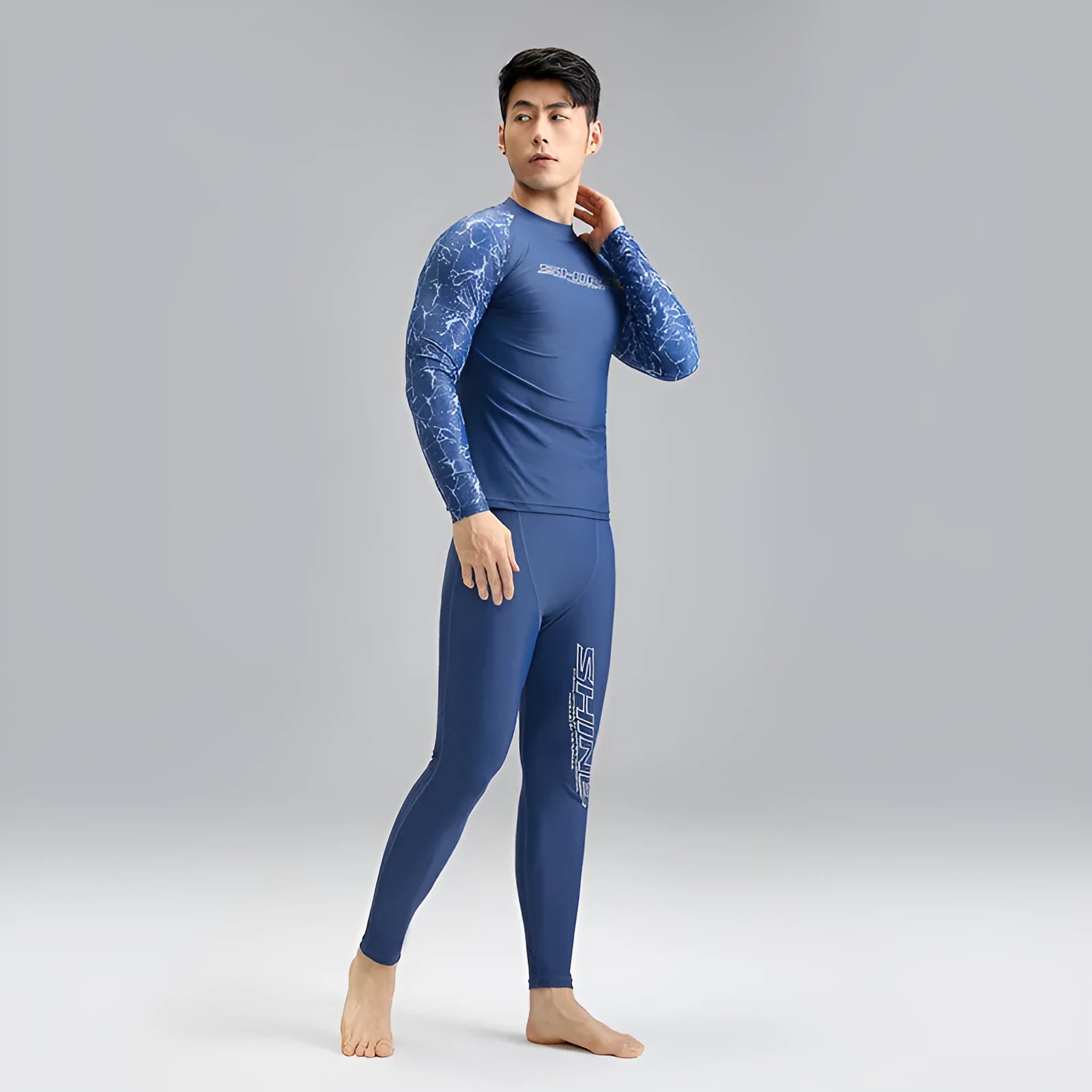 Men's dark blue patterned swim vest and matching swim trunks set on a white background.