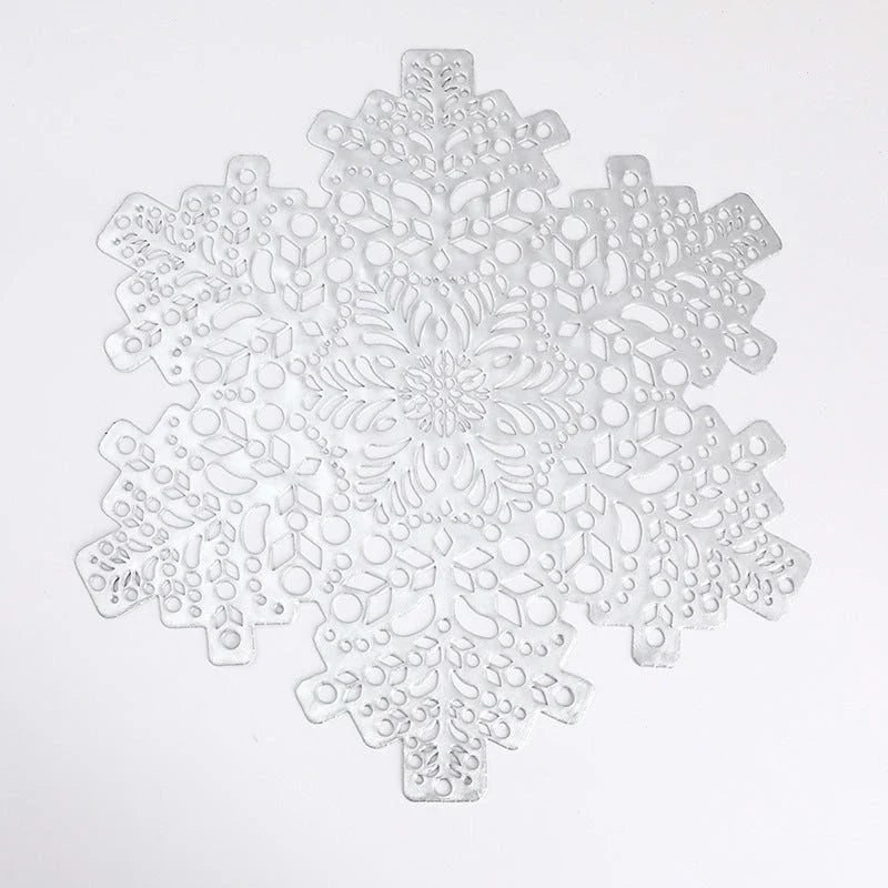 Stylish snowflake-patterned placemats in gold and silver, designed for heat resistance and spill protection on dining tables