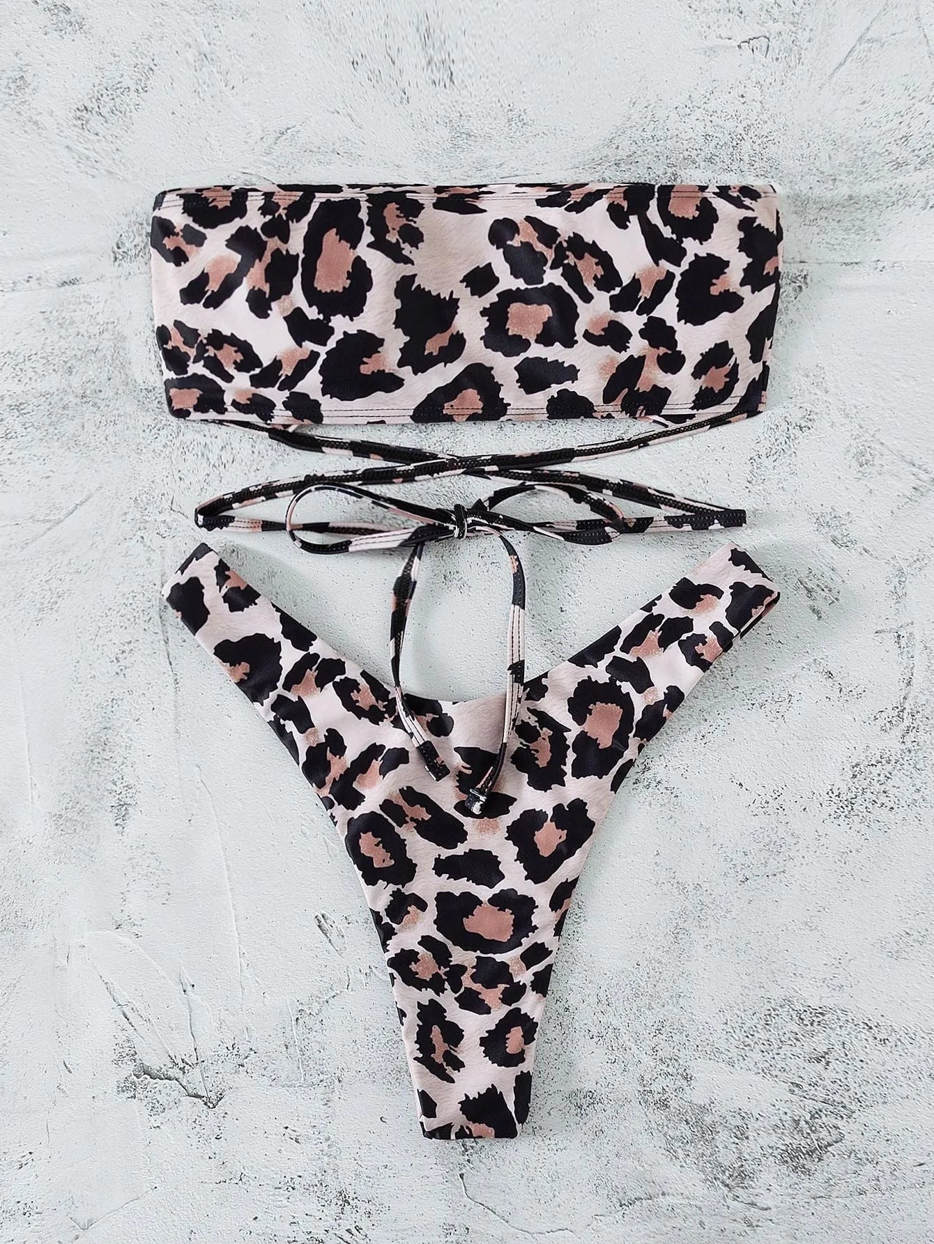 Leopard print bandeau split bikini swimsuit with removable chest pads on woman at beach