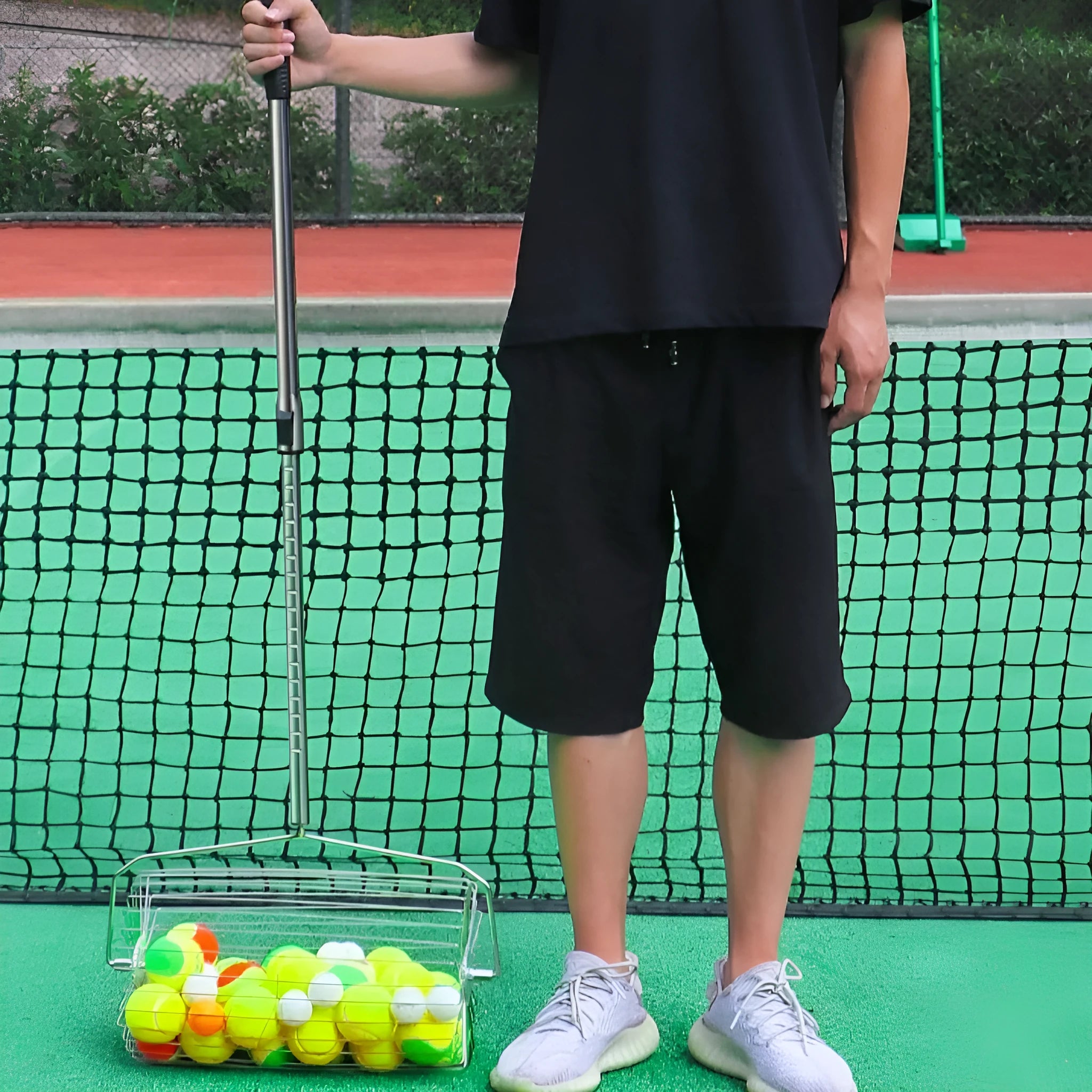 Stainless steel roller tennis ball picker with adjustable collection basket on tennis court
