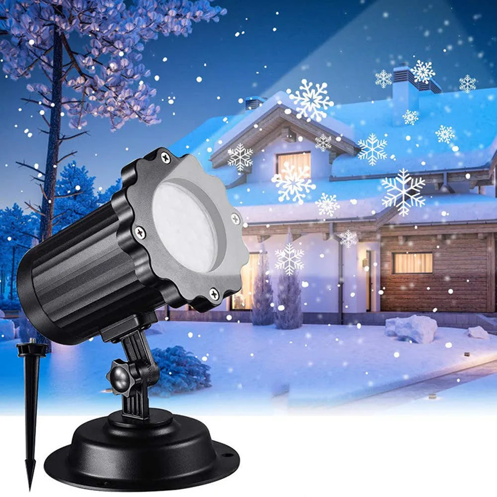LED Christmas snowflake laser projector with white snowfall pattern on a garden lawn at night