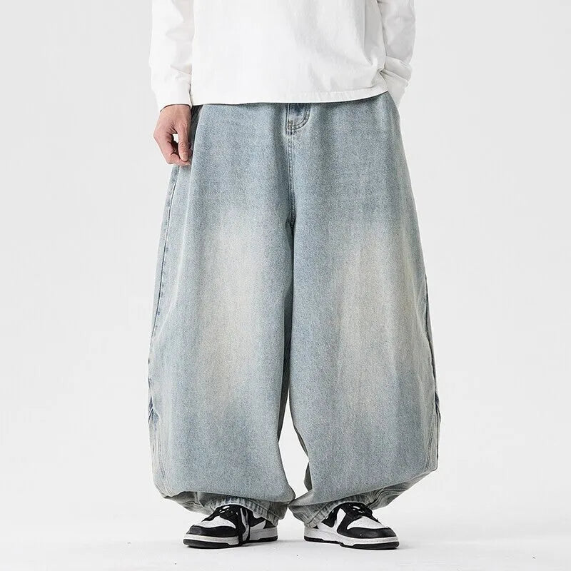 Men's plus-size light blue wide-leg denim jeans with a loose, baggy fit and straight legs on a hanger.