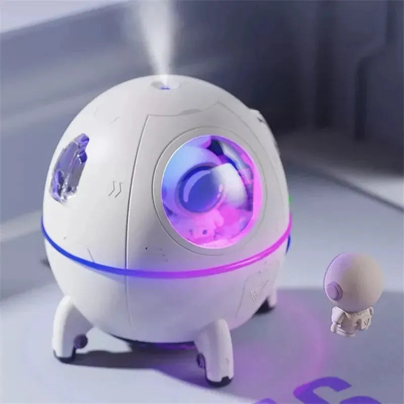 Astronaut-shaped USB desktop humidifier with colourful LED light on a desk.