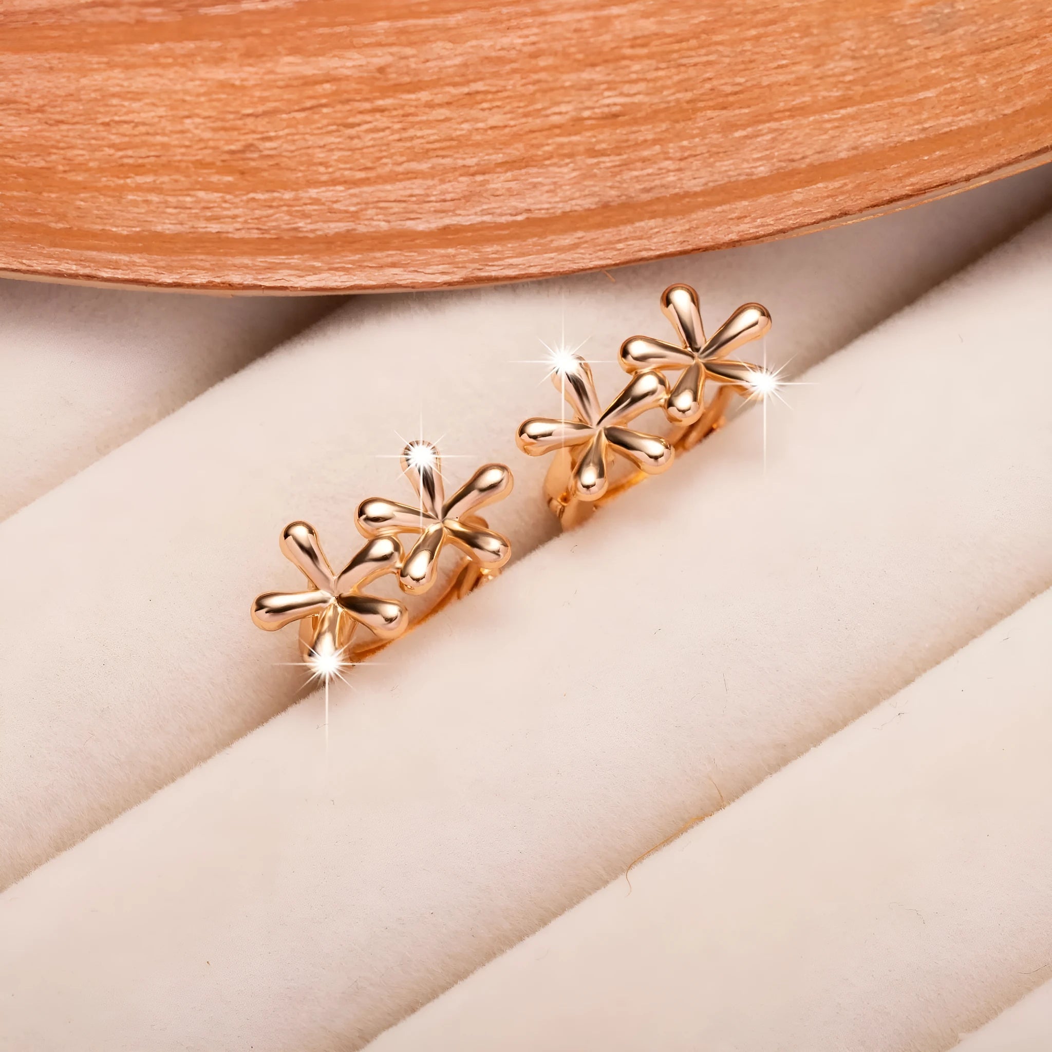 Rose gold circular earrings with a waterdrop flower design.