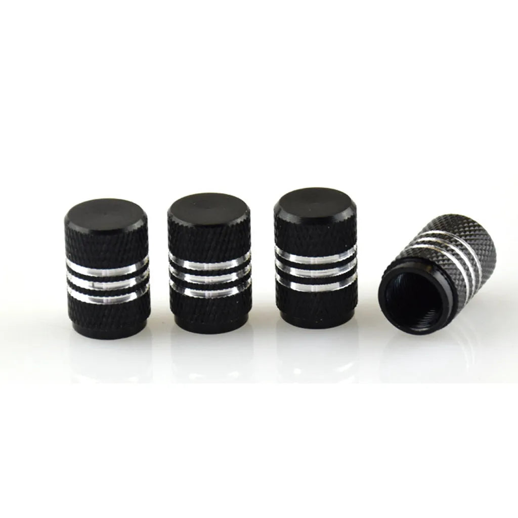 Set of coloured aluminium alloy car tyre valve caps in stainless steel on a grey background.