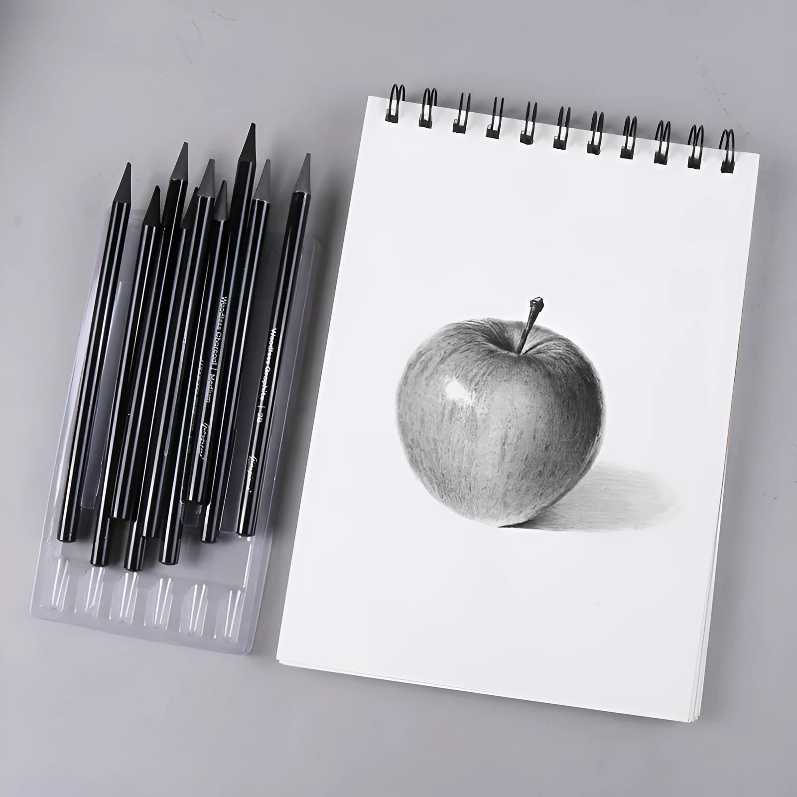Set of graphite and carbonized drawing pencils with wooden barrels on suction card packaging