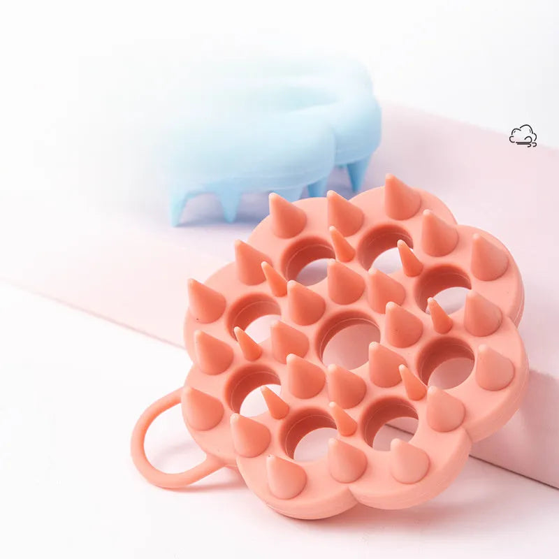 Silicone pet grooming brush with ergonomic handle shown in multiple colours: blue, green, orange, pink, purple.