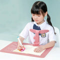 Student anti-myopia seated orthotics posture corrector with silicone chin support on a desk, blue frame