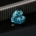 Loose heart-cut moissanite stone in lemon yellow colour on a plain background.