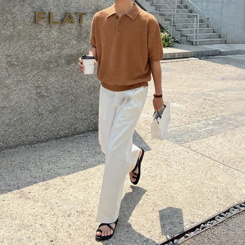 Man modelling a caramel coloured loose-fit knitted short sleeve polo shirt with an asymmetric design.