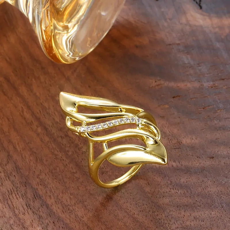 Women's exaggerated curve copper ring with zircon treatment in gold colour