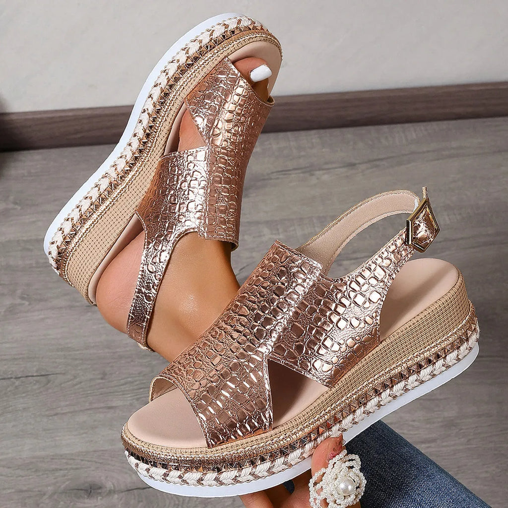 Gold Roman sandals with hollow-out pattern and ankle buckle on model foot