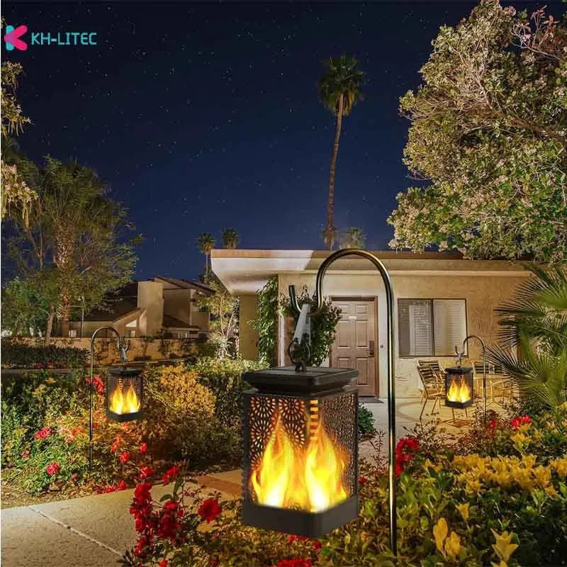 Four black solar-powered hanging lanterns with flickering flame LED light effect for outdoor garden decoration.