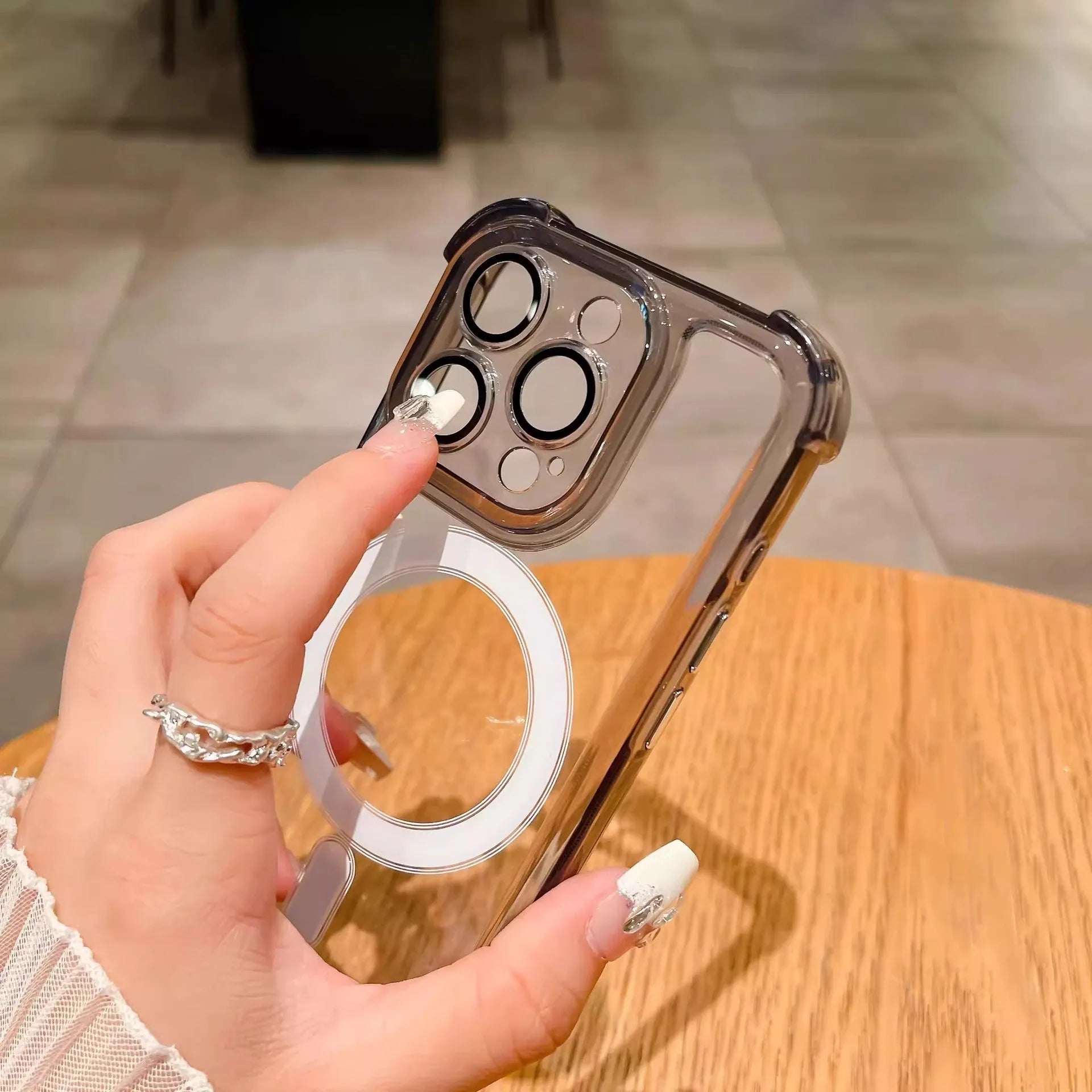 Transparent silicone airbag phone case with magnetic ring and raised camera lens protector for iPhone.