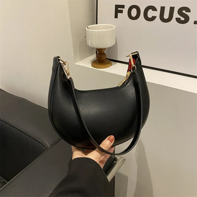 Round women's underarm bag in PU material showing sewing line detailing and internal phone compartment