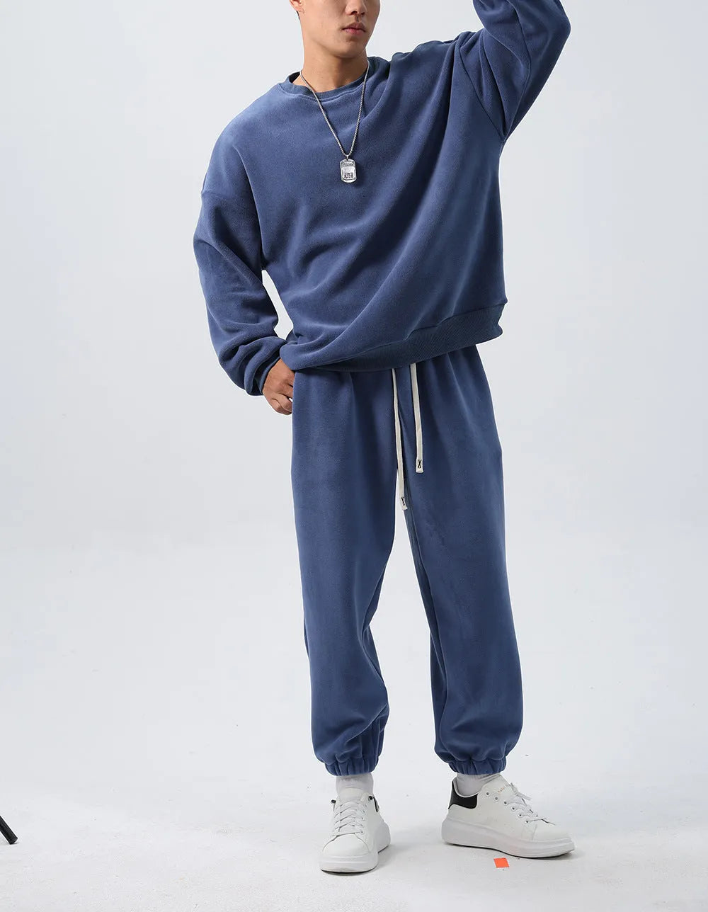 Men's black polar fleece sports suit with crew neck jacket and loose fit trousers laid flat.