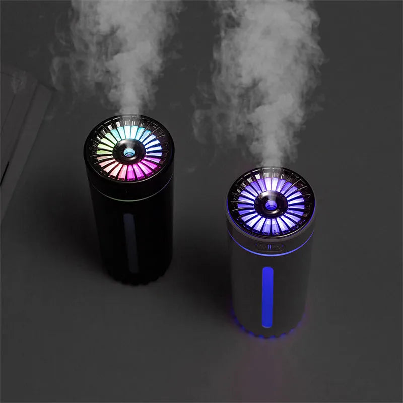 Compact black wireless USB humidifier with colourful LED lights on a car cup holder.
