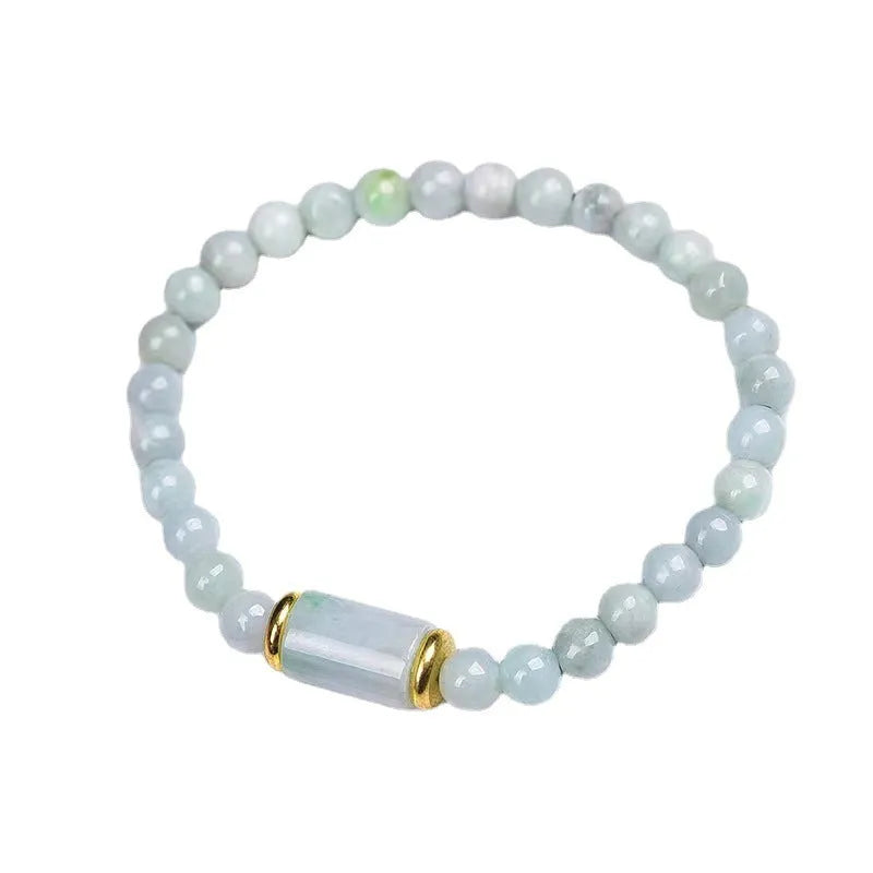 Close-up of a geometric jade bracelet with round emerald-coloured beads on a wrist.