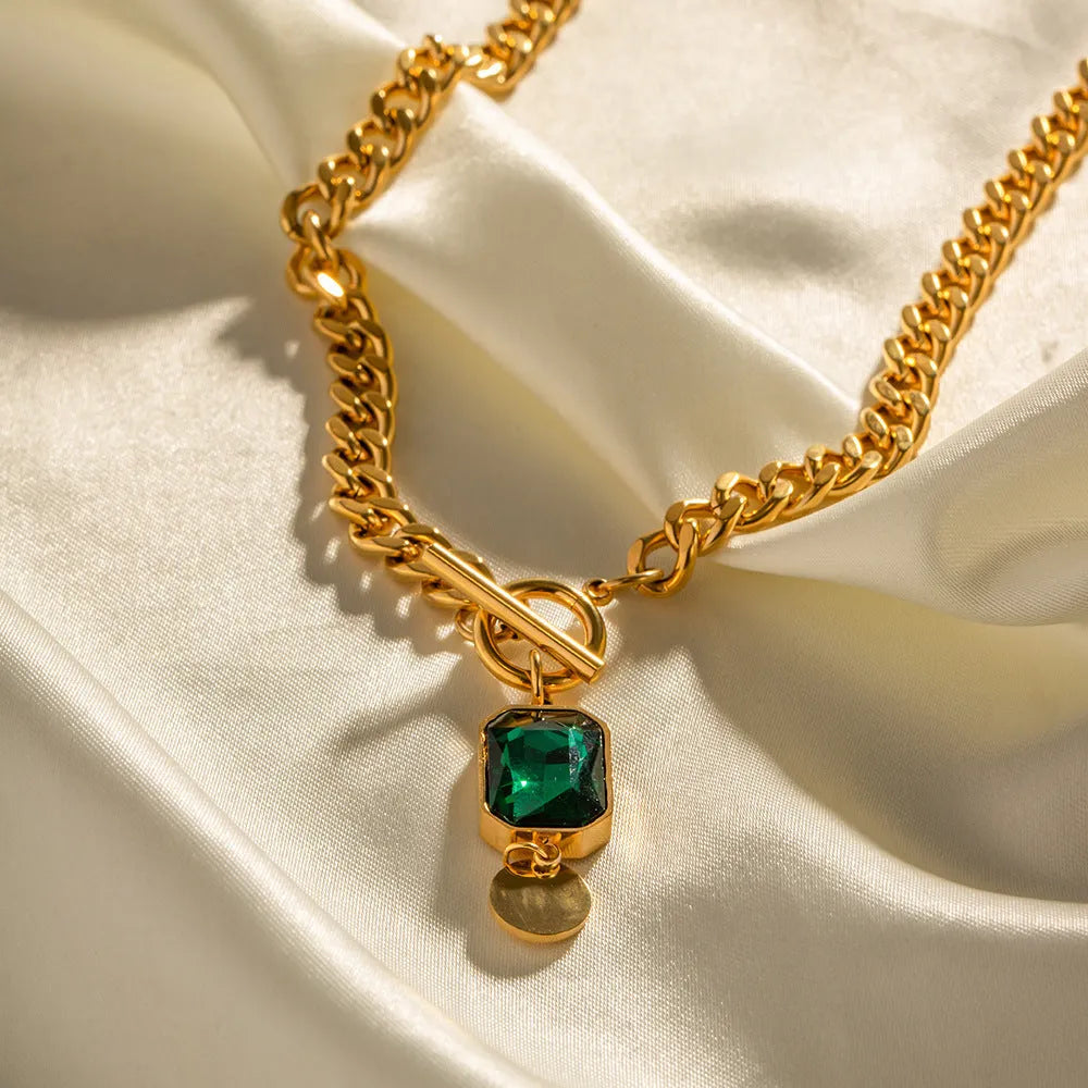 Gold titanium steel necklace with geometric pendant containing emerald zircon stone
