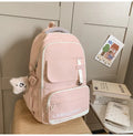Large black nylon school backpack with curved straps, shown with and without a decorative pendant.