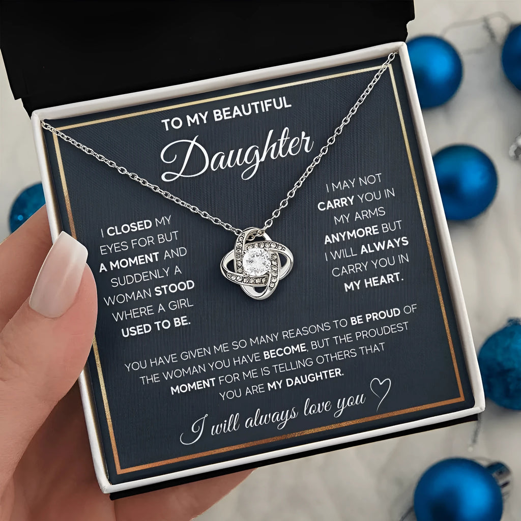 Silver metal four-leaf clover hollow jeweled pendant clavicle chain on display with geometric shape and card beside flip gift box