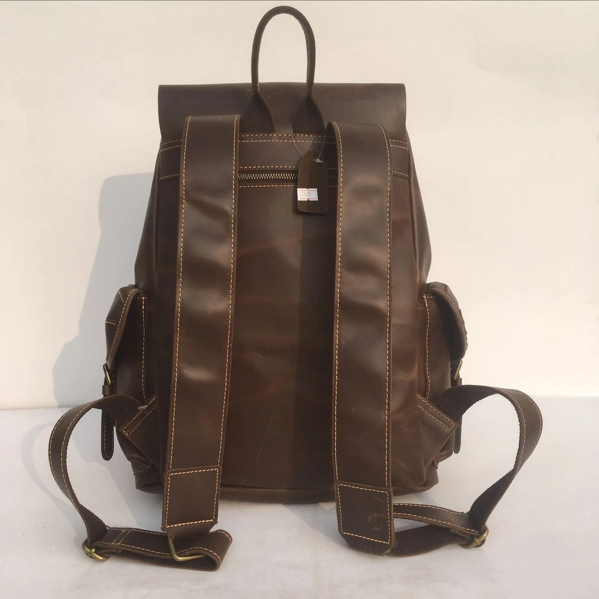 Brown men's leather backpack with an air pillow belt on the straps.