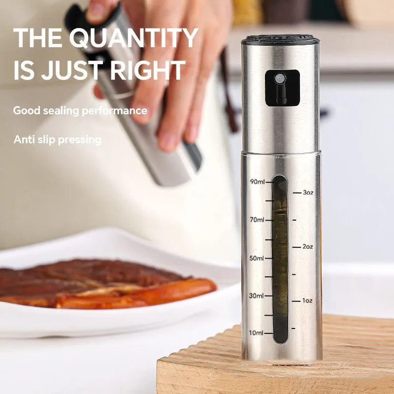 Stainless steel press-type oil injection bottle with 100ml capacity and glass body on kitchen counter