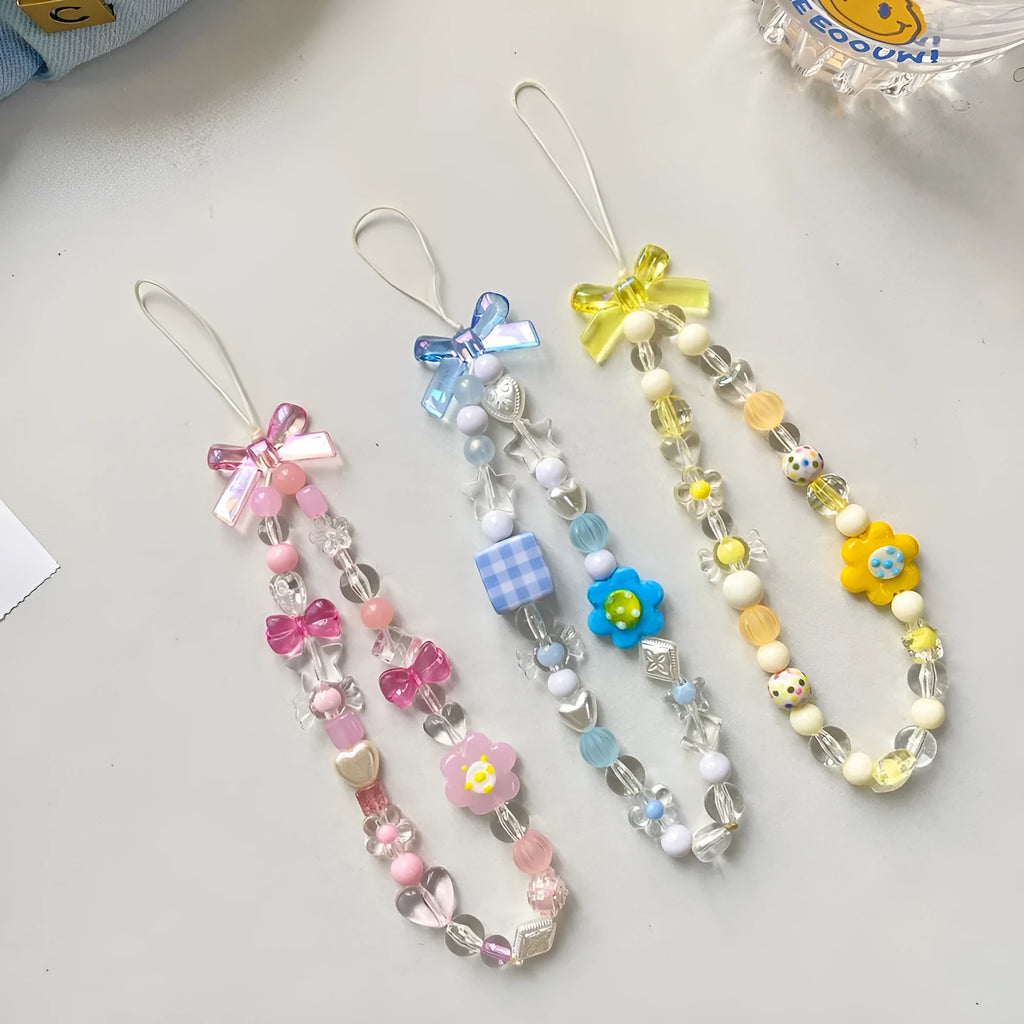 Yellow beaded mobile phone lanyard with a plastic flower charm on an adjustable strap.