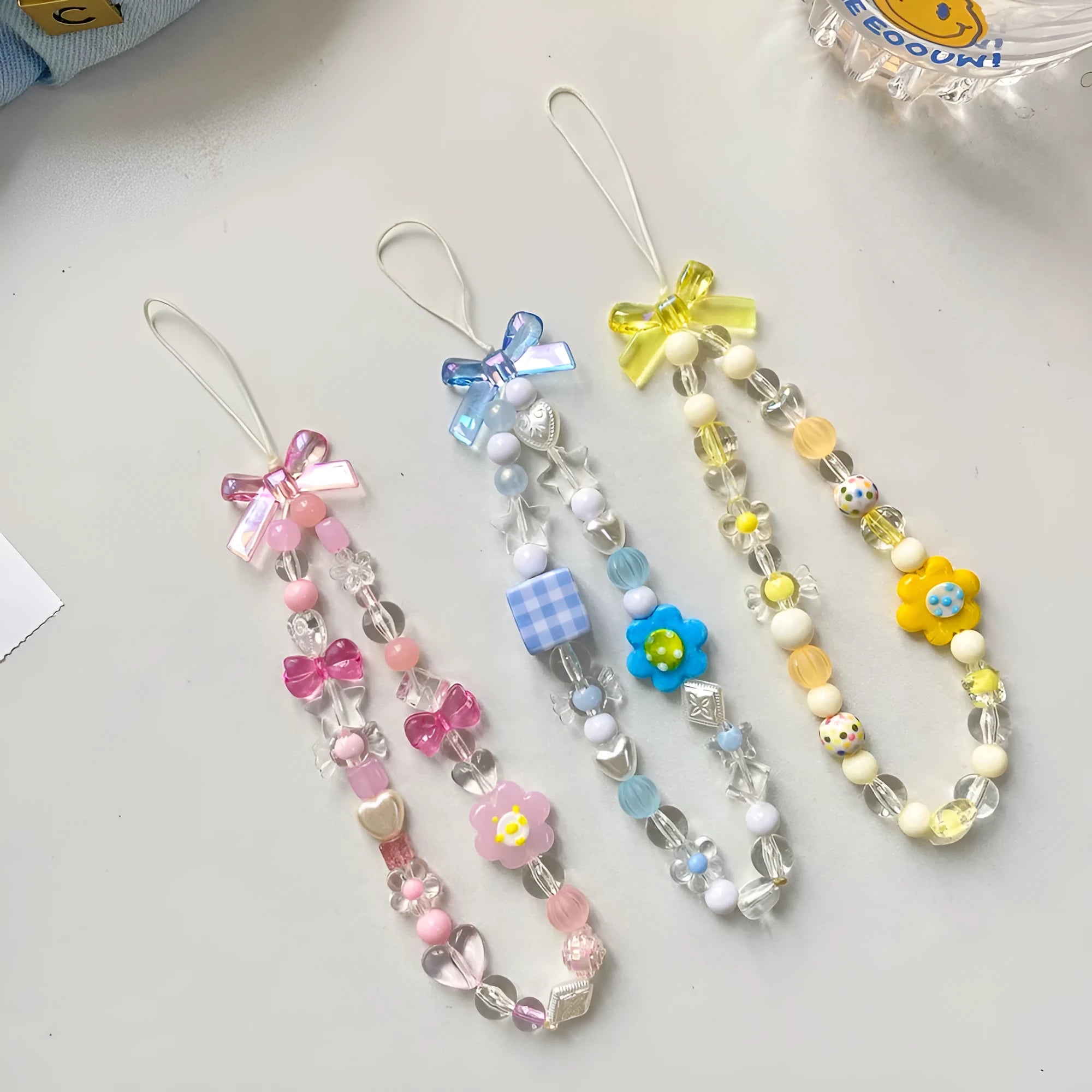 Yellow beaded mobile phone lanyard with a plastic flower charm on an adjustable strap.