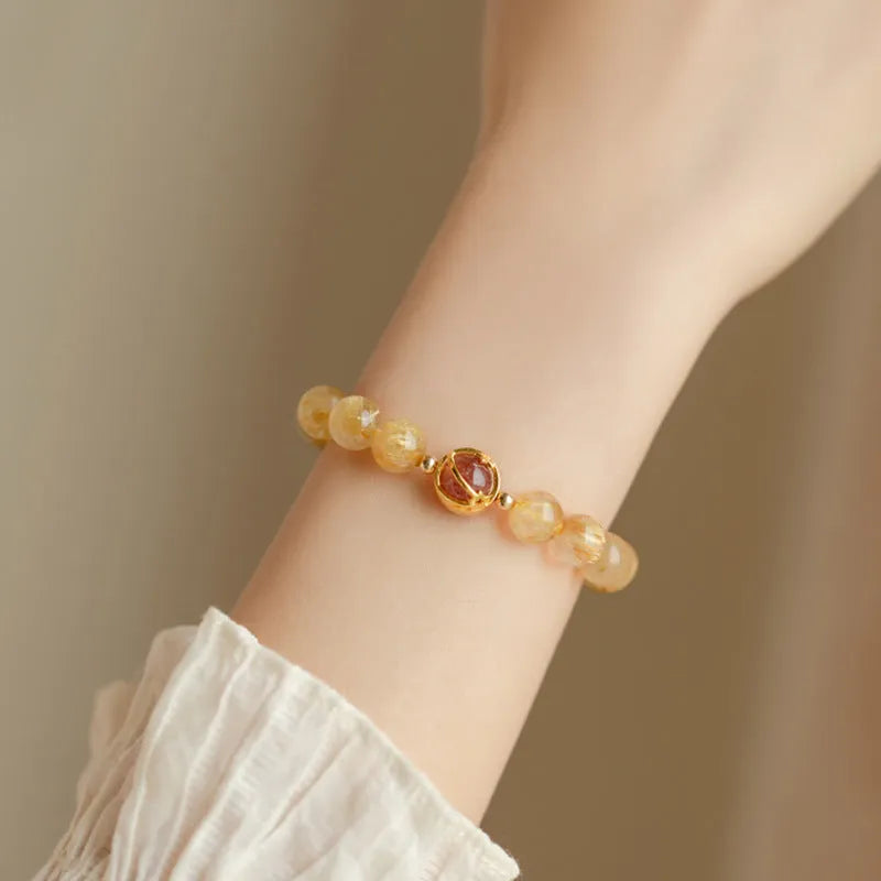 Gold rutilated quartz crystal bracelet with diamond-shaped links and natural citrine beads