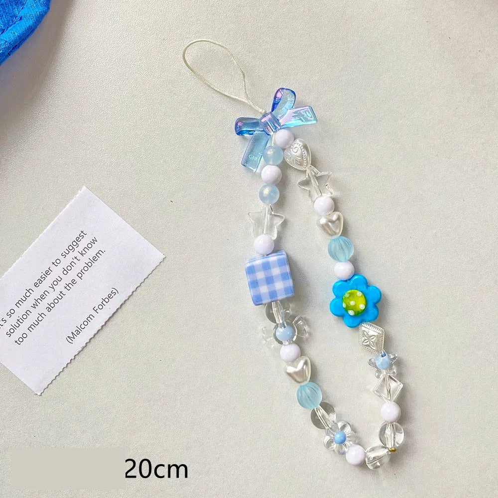 Yellow beaded mobile phone lanyard with a plastic flower charm on an adjustable strap.