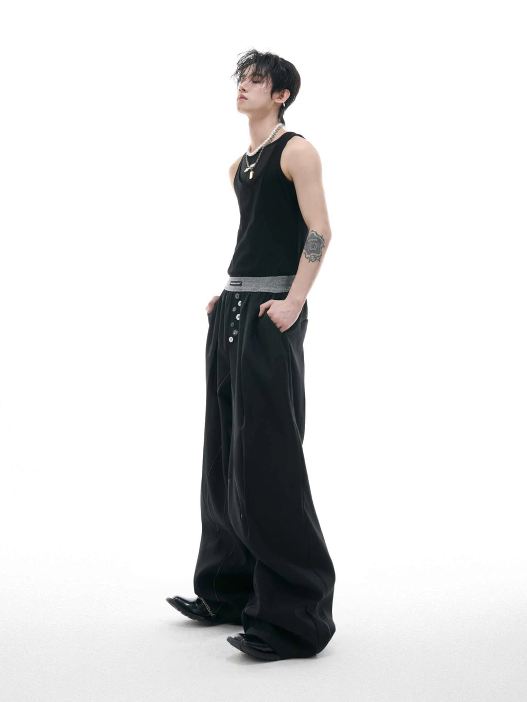 High-waist straight-leg trousers with a button detail on the leg in black or grey.