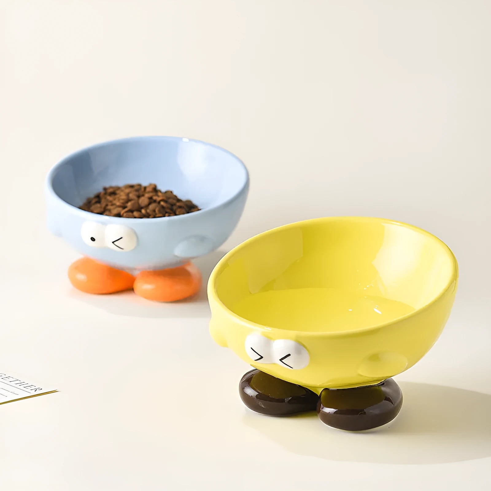 Blue tall ceramic pet food bowl with oblique shape and a silicone non-slip ring on the base.
